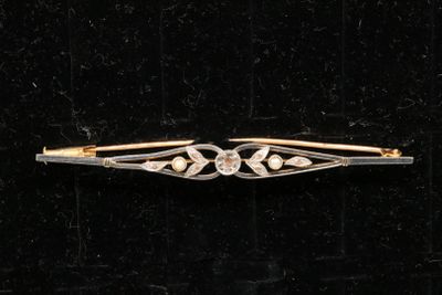a close up of a gold and diamond hair clip on a black velvet surface