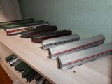 Plusieurs petits trains sont alignés sur une étagère dans une pièce