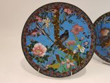 two decorative plates with birds and flowers on them