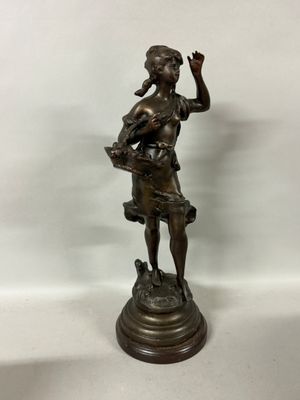 a bronze statue of a woman holding a basket of flowers