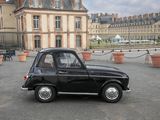 a small black car that is parked in a parking lot