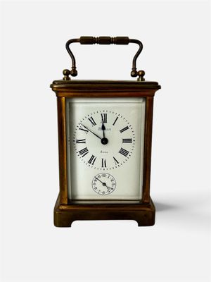 une petite horloge en bois avec des chiffres romains