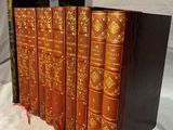 trois livres sont empilés sur une surface blanche