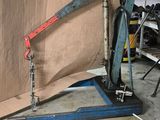 un homme debout dans un garage, tenant un gros morceau de bois