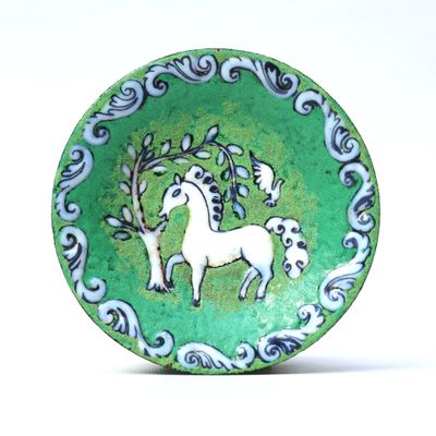 a green plate with a picture of a white horse on it