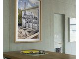 a picture hanging on the wall above a wooden table