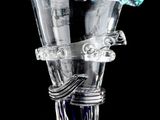 un vase en verre transparent avec une anse bleue sur fond noir