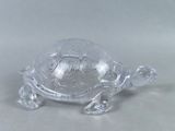 une figurine de tortue en verre posée sur une table