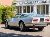 a silver sports car parked in front of a building