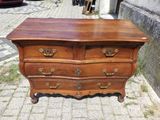 une commode en bois posée sur le trottoir