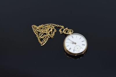 an image of a gold pocket watch with a chain on a black surface