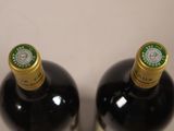 two bottles of wine sitting next to each other on a table