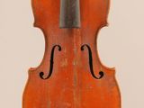 un vieux violon posé sur une surface blanche