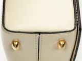 a close up of a white purse with gold studded handles