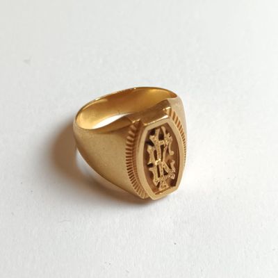 une image représentant une chevalière en or sur laquelle figure une horloge