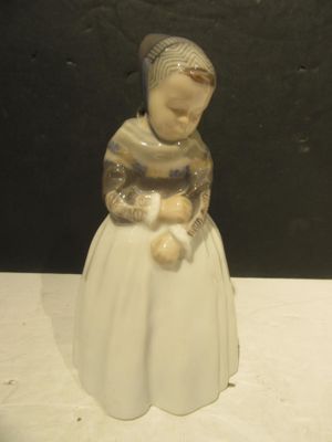 une figurine représentant une femme tenant un ours en peluche