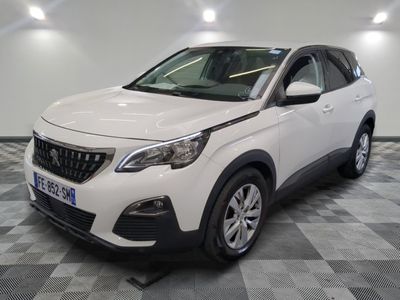 la voiture blanche est garée sur un sol en damier dans le garage