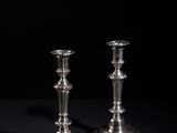 pair of silver candlesticks on a black background
