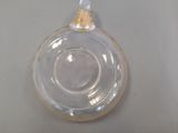 a clear glass ornament with a gold top on a table