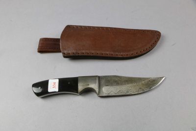a knife and sheath on a table next to each other