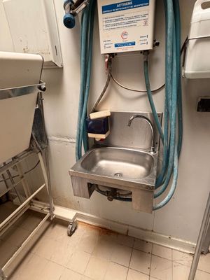 a sink with a hose attached to it in a bathroom