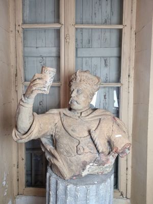 une statue représentant un homme tenant une coupe dans une pièce