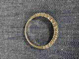une photo d'une bague en or posée sur un tissu noir