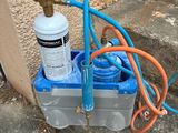 an image of a water filtrator and a hose on the ground