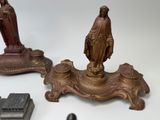two statues of jesus and a statue of a woman on a table