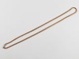 a gold necklace with a chain on a white background