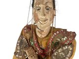 a wooden sculpture of a man with a bird on his head