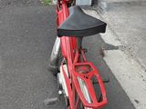 a red scooter that is parked on the side of the road
