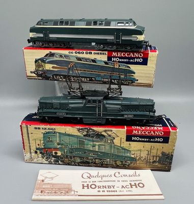 trois trains miniatures dans leurs boîtes, empilés les uns sur les autres sur une table