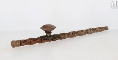 une pipe avec un manche en bois posée sur une surface blanche