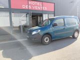 une petite camionnette bleue garée devant un hôtel