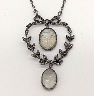 collier en argent orné d'une pierre blanche et d'un motif de feuille, monté sur une chaîne