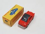 a red toy car next to a yellow box on a white surface