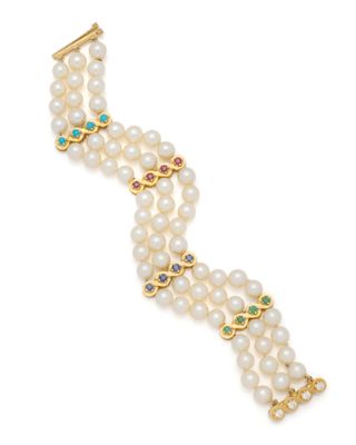 un gros plan sur un bracelet orné de perles et d'émeraudes