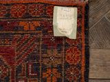 an old rug with a tag on it sitting on a wooden floor