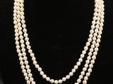 un collier de perles à trois rangs présenté sur un mannequin