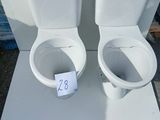 two toilets sitting on a table with a price tag on it