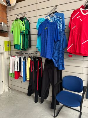 une pièce avec un portant de vêtements de sport et une chaise