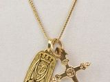 un collier en or orné d'un oiseau et d'une croix
