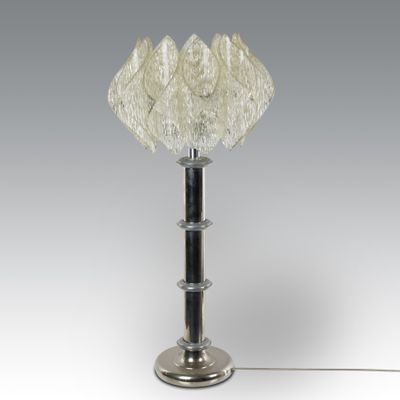 a close up of a lamp on a metal pole with a glass shade