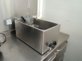 stainless steel counter top with two deep fryers on top of it
