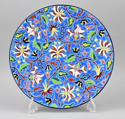 un gros plan d'une assiette bleue décorée de fleurs et de feuilles