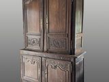 une grande armoire en bois avec un plateau sculpté