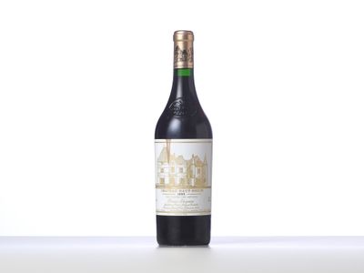 a bottle of wine sitting on top of a table next to a bottle of wine