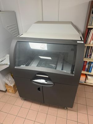 une photo d'une imprimante dans une pièce où se trouve une bibliothèque