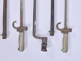 several old tools are hanging on a wall on a white surface